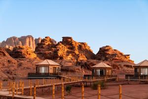 a group of cottages in front of a mountain at The Villas - Bedouin Boutique Resort in Wadi Rum