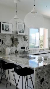 a kitchen with a marble counter top and black chairs at Résidence & Hôtel Aria Marina in Propriano