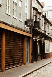 un panneau sur le côté d'un bâtiment dans une rue dans l'établissement HIDEOUT Hotel, à Hull