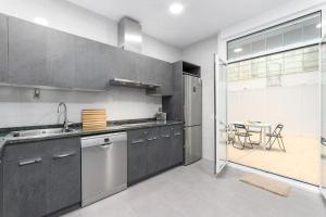 a kitchen with stainless steel appliances and a table at House Riberas in Loyola