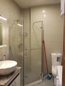 a bathroom with a glass shower and a toilet at Стильная квартирка у моря in Batumi