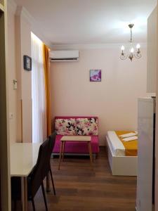a room with a couch and a table and a bed at Стильная квартирка у моря in Batumi