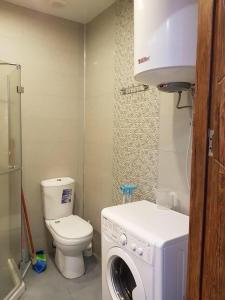 a bathroom with a washing machine and a toilet at Стильная квартирка у моря in Batumi
