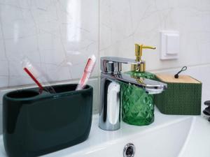 a toothbrush holder sitting on a sink with a toothbrush at Apartament Classic Comfort Aleja NMP 8 - Free parking in Częstochowa