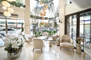 um átrio com cadeiras brancas, mesas e flores em Bentley Hotel Bosphorus - Special Class em Istambul