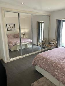 1 dormitorio con espejo, 1 cama y 1 silla en Serra de Arga Mountain House, en Montaria