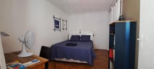 - une chambre avec un lit bleu et un ventilateur dans l'établissement vue sur Rhône, à Lyon