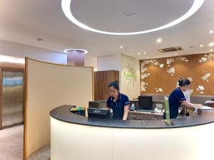 two women standing at a desk in an office at Liberty 2 Hotel in Ho Chi Minh City