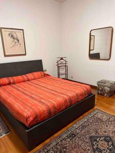 um quarto com uma cama, um espelho e um tapete em A casa di Gianni em Gallarate
