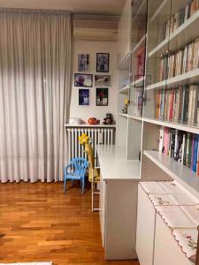 uma sala com uma biblioteca com uma secretária e livros em A casa di Gianni em Gallarate