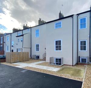 a row of white houses in a parking lot at Penshaw Boutique Apartment in Sunderland