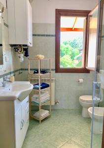 a bathroom with a sink and a toilet and a window at Edera in Porto Corsini