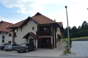 a building with cars parked in a parking lot at Apartment Nadja in Zlatibor