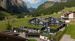 uma vista aérea de um resort nas montanhas em Biancaneve Family Hotel em Selva di Val Gardena