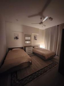 1 dormitorio con 2 camas y ventilador de techo en One Bedroom Al Hail DT, en Ḩayl Āl ‘Umayr