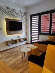 - un salon avec un canapé et une télévision dans l'établissement Sky Apartments, à Strumica