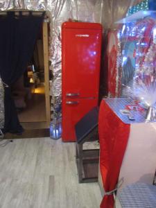 einen roten Kühlschrank in einem Zimmer mit einem Tisch in der Unterkunft Fetish-Hostel in Dresden