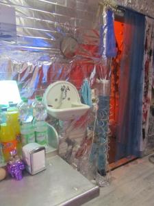 ein Badezimmer mit einem Waschbecken in einem Zimmer mit Plastikfolie in der Unterkunft Fetish-Hostel in Dresden