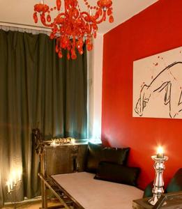 ein Wohnzimmer mit einem Kronleuchter und roten Wänden in der Unterkunft Fetish-Hostel in Dresden