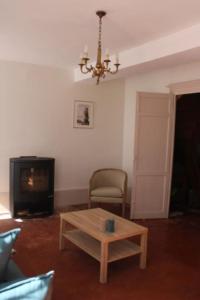 uma sala de estar com uma mesa de centro e um lustre em La Buissonnière em Arnay-le-Duc