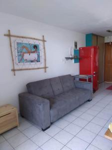 sala de estar con sofá y nevera roja en STUDIO MI AIME AOU, en La Saline-Les-Bains