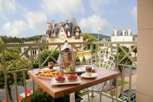 a tray of food sitting on a table on a balcony at Résidence La Closerie Deauville in Deauville
