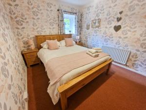 a bedroom with a large bed and a window at Langriggs at Wetheral Cottages in Great Salkeld