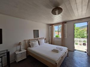 a bedroom with a bed and a large window at Elena Apartments in Vathi