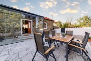 a patio with a wooden table and chairs at Sunny Hill in Vremski Britof