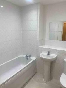 a bathroom with a sink and a tub and a toilet at Colchester Smart Two Bed Apartment in Colchester