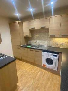 een keuken met een fornuis en een wasmachine bij Colchester Smart Two Bed Apartment in Colchester