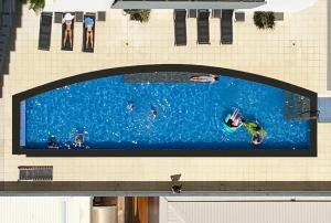 une grande photo de personnes nageant dans une piscine dans l'établissement “PENZANCE” Great Location & Views at PenthousePads, à Darwin