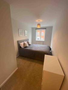 a bedroom with a bed and a window at Colchester Smart Two Bed Apartment in Colchester