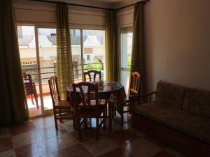 a dining room with a table and chairs and a couch at Acogedor apartamento en l'Estartit in L'Estartit