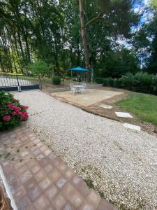 a patio with a picnic table and a blue umbrella at Les Loisons in Beauvoir