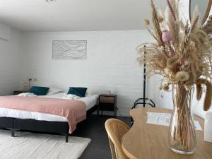 Un dormitorio con una cama y una mesa con un jarrón de flores en Perfect getaway in Bruges!, en Brujas