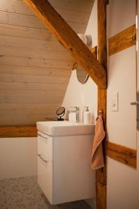 a bathroom with a sink and a wooden ceiling at Mlýn Salajna in Dolní Žandov
