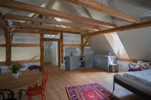 a room with a table and a kitchen in a attic at Mlýn Salajna in Dolní Žandov