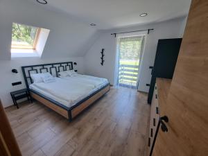 una camera con un letto e una grande finestra di Riverside Apartma 1, Kranjska Gora a Kranjska Gora