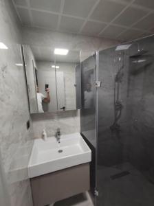 y baño con lavabo, ducha y espejo. en A new Flat close to Nata Vega, en Mamak