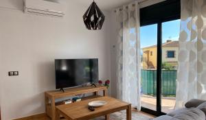 a living room with a flat screen tv and a table at Pinea 12 D in Vilacolum