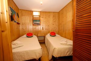 two beds in a room with wooden walls at A74 - Rua do Canal 1 Bed Flat in Lagos