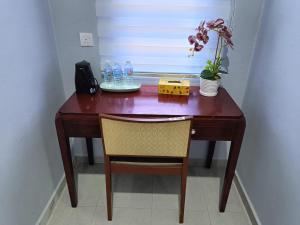 a wooden desk with a chair and water bottles at The Marak Village KB - Mini Homestay in Kota Bharu