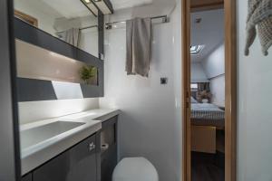 a small bathroom with a sink and a mirror at LUXE Crewed Catamaran, Sailing Mangofloat, Croatia in Split