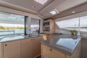 a kitchen with two large windows and a large counter top at LUXE Crewed Catamaran, Sailing Mangofloat, Croatia in Split