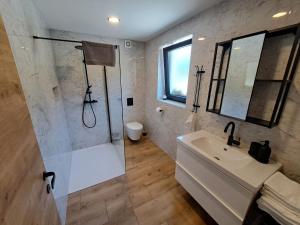 bagno bianco con doccia e lavandino di Riverside Apartma 1, Kranjska Gora a Kranjska Gora