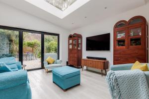 uma sala de estar com duas cadeiras azuis e uma televisão em Middle Chine em Bournemouth
