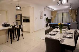 uma cozinha e uma sala de estar com uma mesa e uma mesa de bilhar em Teega Modern 4BR 12pax pooltable by Our Stay em Nusajaya