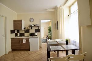 a kitchen and dining room with a table and a refrigerator at EcoStay Apartment by the Basilica in Budapest