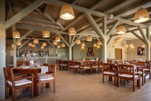 a restaurant with wooden tables and chairs and a bar at Green Village Resort in Sfântu Gheorghe